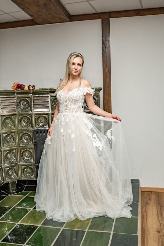 Frau im weißen Brautkleid vor Ofen