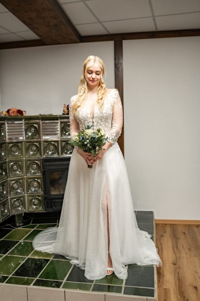 Braut im weißen Kleid mit Blumenstrauß