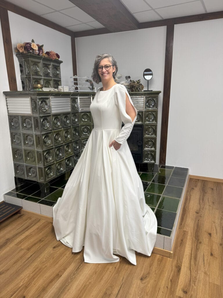 Person im weißen Kleid vor Ofen stehend.