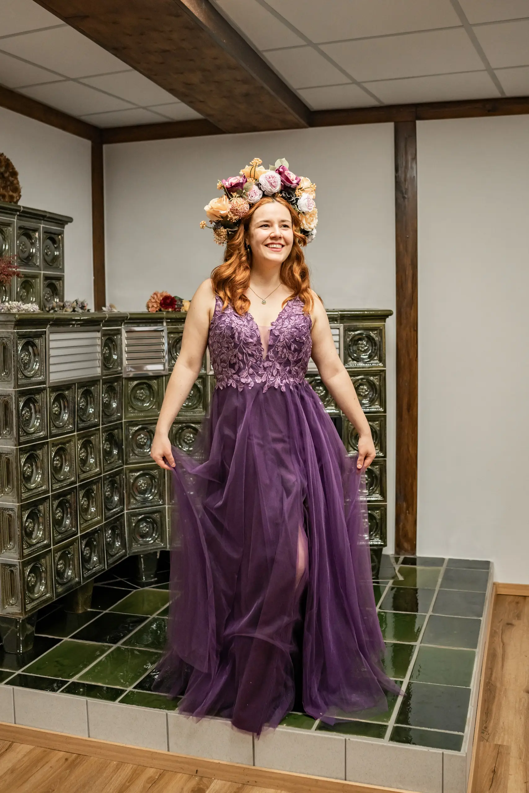 Lächelnde Frau im lila Kleid mit Blumenkrone