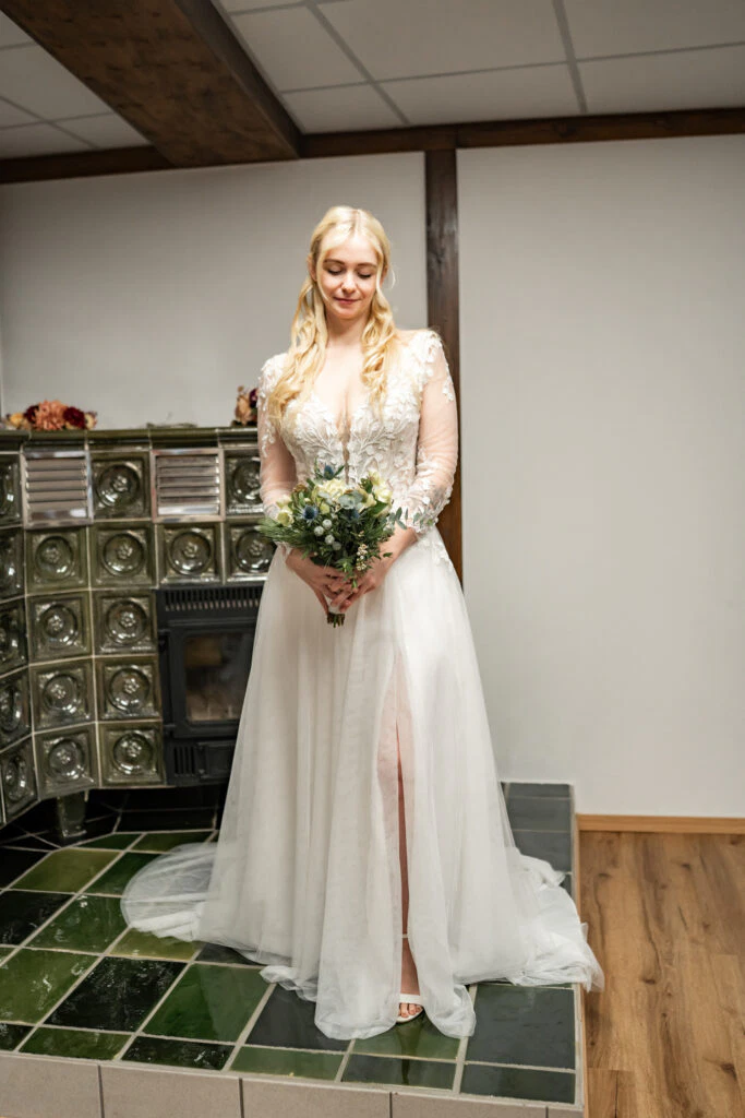 Braut im weißen Kleid mit Blumenstrauß