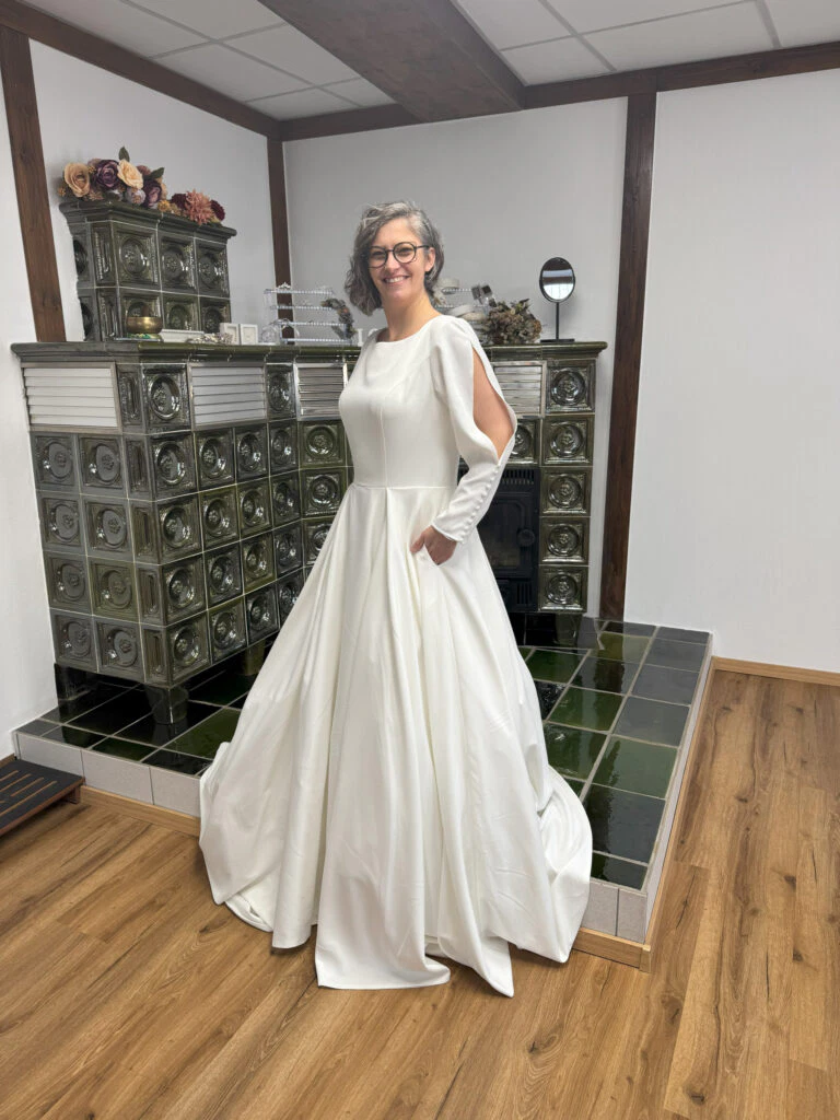 Person im weißen Kleid vor Ofen stehend.