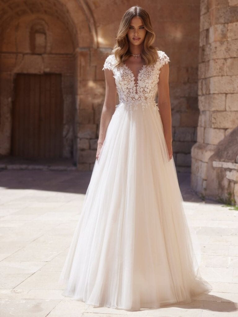 Brautkleid mit Spitzendetails vor antiker Kulisse