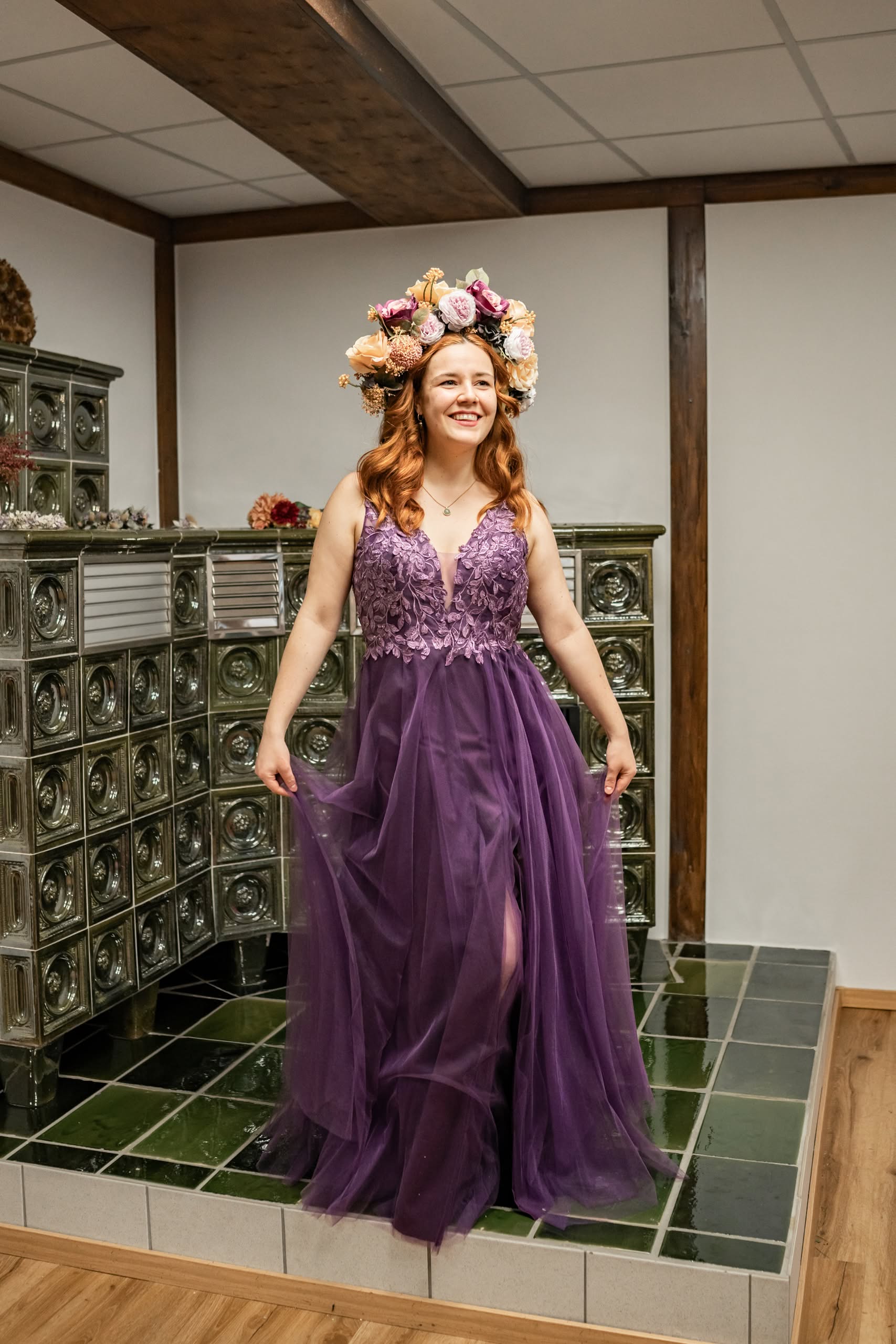 Lächelnde Frau im lila Kleid mit Blumenkrone