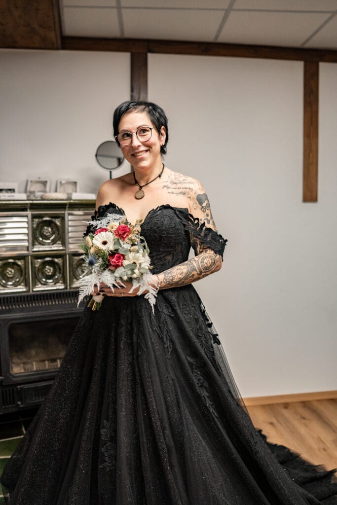 Frau im schwarzen Kleid mit Blumenstrauß